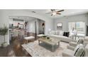 Bright living room with hardwood floors, neutral-toned furniture, and an open layout to the kitchen at 1546 Water Elm Ct, Orlando, FL 32825