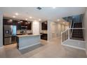 Open kitchen with granite countertops, stainless steel appliances, and an adjacent staircase at 3987 Sagefield Dr, Harmony, FL 34773