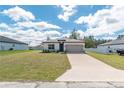 Charming one-story home with a well-kept lawn, concrete driveway, and an attached two-car garage at 8908 Sw 133Rd Ln, Ocala, FL 34473