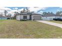 Attractive single-story home boasting a two-car garage, lush lawn, and manicured landscaping at 8908 Sw 133Rd Ln, Ocala, FL 34473