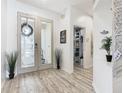 Bright foyer with wood-look floors, glass doors, stylish decor, and a peek into a well-organized storage area at 2911 Sunset Vista Ct, Kissimmee, FL 34747