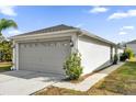 Two-car garage of home featuring light-grey paint, a concrete driveway, and maintained landscaping at 1533 Loch Avich Rd, Winter Garden, FL 34787
