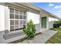 Home exterior featuring light-grey paint, a green front door, and a well-maintained walkway at 1533 Loch Avich Rd, Winter Garden, FL 34787
