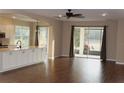 Open living space with wood floors and sliding glass doors leading to a patio at 3621 Arlington Ridge Blvd, Leesburg, FL 34748