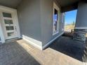 View of the covered front porch featuring a brick paver floor and stone-accented columns at 1342 Twelve Oaks Rd, Saint Cloud, FL 34771