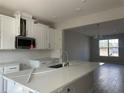Modern kitchen featuring white cabinets, stainless steel appliances, and a quartz island at 1344 Lumpini St, Saint Cloud, FL 34771