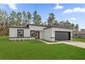 Beautiful home featuring a white exterior, black trim, lush green lawn and large front yard at 15123 Sw 61St Court Rd, Ocala, FL 34473