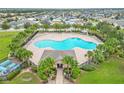 Aerial view of community pool with surrounding lounge chairs and landscaping at 171 Pheasant Dr, Haines City, FL 33844