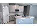 Modern kitchen features stainless steel appliances, white cabinets, and center island at 1165 Basalt Ln, Sanford, FL 32771