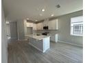 Bright kitchen featuring white cabinets, stainless steel appliances, and a kitchen island at 1360 Lumpini St, St Cloud, FL 34771