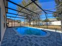 Enclosed pool with brick surround provides the perfect oasis for relaxation, set against a sunny outdoor backdrop at 2387 Laurel Blossom Cir, Ocoee, FL 34761