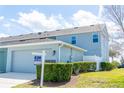 Rear exterior view of the home with an attached garage and well-maintained lawn at 522 Juniper Springs Dr, Groveland, FL 34736
