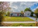 Newly renovated single story home with red door and spacious lawn at 4533 San Sebastian Cir, Orlando, FL 32808