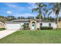 Single-story home with solar panels, a well-manicured lawn, and a light-blue front door, perfect for a modern homeowner at 1053 E Hancock Dr, Deltona, FL 32725
