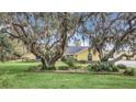 Charming yellow home surrounded by mature trees and green lawn at 4750 Rummell Rd, St Cloud, FL 34771