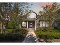 Charming two-story home with manicured lawn and inviting front porch under a colorful evening sky at 8677 Pinter St, Orlando, FL 32827