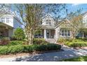 Beautifully landscaped home with a welcoming front porch and blue accents on a bright, sunny day at 8677 Pinter St, Orlando, FL 32827
