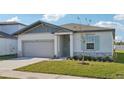 Newly built home with gray siding, light green accents, and well-manicured lawn at 2149 Rosewood Dr, Bartow, FL 33830