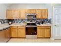 Well-equipped kitchen with stainless steel appliances, tiled backsplash, and ample cabinet space at 3529 Sanctuary Dr, St Cloud, FL 34769