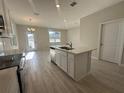Contemporary kitchen features a center island with a sink, light wood-style flooring and a bright, open design at 9332 Bolshoi Aly, Winter Garden, FL 34787