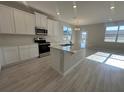Bright, all-white kitchen features a center island with a sink, stainless steel appliances, and a light, open floor plan at 9332 Bolshoi Aly, Winter Garden, FL 34787