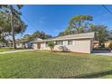 Charming single-story home with a well-manicured lawn and a red front door, set on a sunny day at 1009 Perkins St, Leesburg, FL 34748