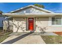 Inviting front entrance featuring a vibrant red door, modern lighting, and updated exterior at 1009 Perkins St, Leesburg, FL 34748