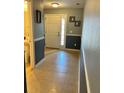 Inviting hallway with tile flooring leading to a bright front door, complemented by decorative wall accents at 1952 Dunn Cove Dr, Apopka, FL 32703