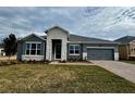 Single-story home with gray siding, stone accents, and a two-car garage at 371 Lady Palm St, Apopka, FL 32703