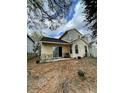 View of a large backyard with mature trees and a cozy patio seating area at 6776 Brittany Chase Ct, Orlando, FL 32810