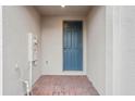 Front entry of townhome with brick flooring and a blue door at 16387 Happy Eagle Dr, Clermont, FL 34714