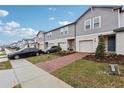 Townhome with brick paver driveway, landscaping, and two-car garage at 16387 Happy Eagle Dr, Clermont, FL 34714