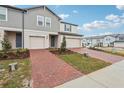 Two-story townhome with a brick paver driveway and landscaping at 16387 Happy Eagle Dr, Clermont, FL 34714