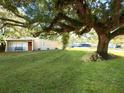 Single story home nestled under a large oak tree with a spacious lawn at 301 E 26Th St, Sanford, FL 32773