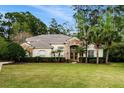 Beautiful home with a lush green lawn, mature trees, and a charming stone and stucco facade at 943 Elm Harbor Ct, Lake Mary, FL 32746