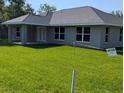 Well-maintained single-story home featuring a covered porch and expansive backyard, creating an inviting outdoor space at 8749 Se 159Th Ln, Summerfield, FL 34491