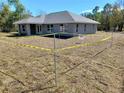 New construction home featuring gray stucco and roof and an ample yard awaiting a future garage to be installed at 8749 Se 159Th Ln, Summerfield, FL 34491