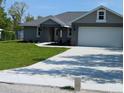 Beautifully landscaped single-story house with a spacious driveway and manicured lawn, perfect for suburban living at 8749 Se 159Th Ln, Summerfield, FL 34491