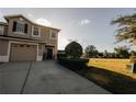 Charming two-story home showcasing a manicured lawn and a spacious driveway leading to a one-car garage at 13910 Dove Wing Ct, Orlando, FL 32828