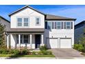 Two-story home featuring a two-car garage, blue front door, and manicured landscaping at 11218 Pixie Mandarin Ct, Winter Garden, FL 34787