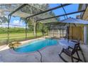 Inviting pool area with screened enclosure, patio furniture, and lush landscaping at 315 Aldridge Ln, Davenport, FL 33897