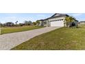 Landscaped yard with a brick driveway leading to the house at 3161 Indian Trl, Eustis, FL 32726