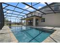 Backyard pool with dark metal screen and patio with ceiling fan, perfect for outdoor relaxation and entertaining at 3303 Kayak Way, Orlando, FL 32820