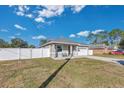 Single story house with gray exterior, white fence, and small front yard at 1460 3Rd Ave, Deland, FL 32724