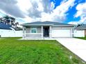 Newly built home with gray siding, white garage door, and well-manicured lawn at 1460 3Rd Ave, Deland, FL 32724