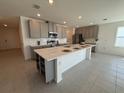 Modern kitchen featuring a large island and stainless steel appliances at 6635 Tempo Way, Mascotte, FL 34753