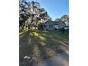 Single-story home with a large front yard and mature trees at 12680 Sw 98Th St, Dunnellon, FL 34432