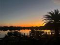 Breathtaking sunset view over the tranquil lake, reflecting light off docks lined with palm trees at 16659 Broadwater Ave, Winter Garden, FL 34787