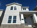Charming two-story home featuring stone accents, light-colored stucco and decorative shingles, and a welcoming front porch at 5318 Center Lake Ranch Blvd, St Cloud, FL 34771