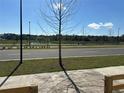 Scenic street view showcasing a tree-lined road and a tranquil pond in the background, under a clear blue sky at 5318 Center Lake Ranch Blvd, Saint Cloud, FL 34771